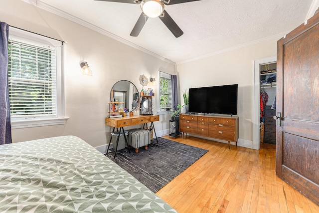 411 Edgemoor Ave, Kalamazoo, MI 49001 - bedroom with light wood-style floors, crown molding, a walk in closet, ceiling fan, and a closet