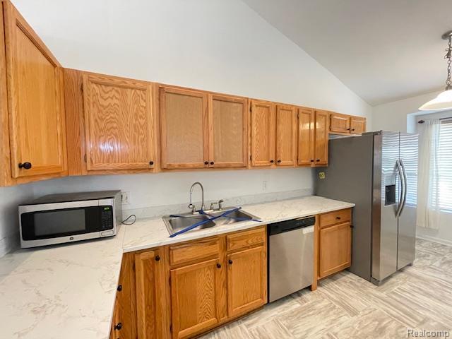 30885 Lee Frank Ln, Madison Heights, MI 48071 - kitchen featuring appliances with stainless steel finishes, brown cabinetry, pendant lighting, light stone counters, and high vaulted ceiling