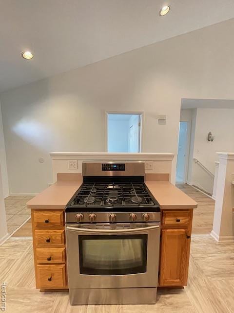 30885 Lee Frank Ln, Madison Heights, MI 48071 - kitchen featuring stainless steel gas range, light countertops, brown cabinets, lofted ceiling, and recessed lighting