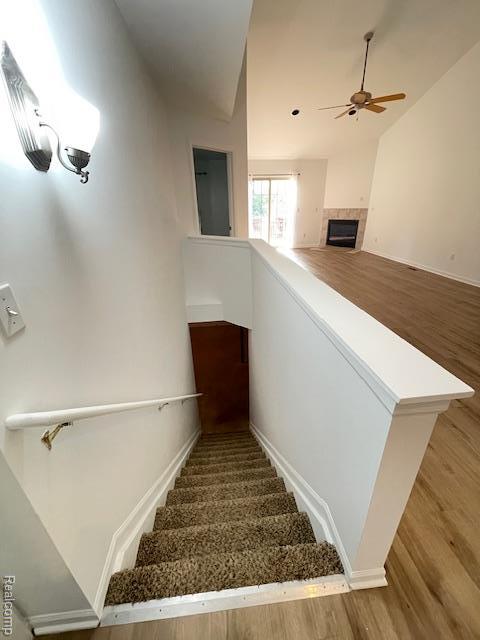 30885 Lee Frank Ln, Madison Heights, MI 48071 - staircase with a ceiling fan, wood finished floors, a fireplace, and vaulted ceiling