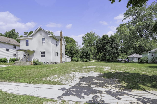 1211 S Jackson St, Jackson, MI 49203 - view of home's exterior featuring a chimney and a lawn