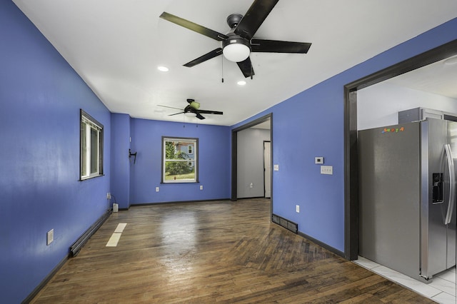 1211 S Jackson St, Jackson, MI 49203 - unfurnished room featuring a baseboard radiator, a ceiling fan, wood finished floors, and recessed lighting