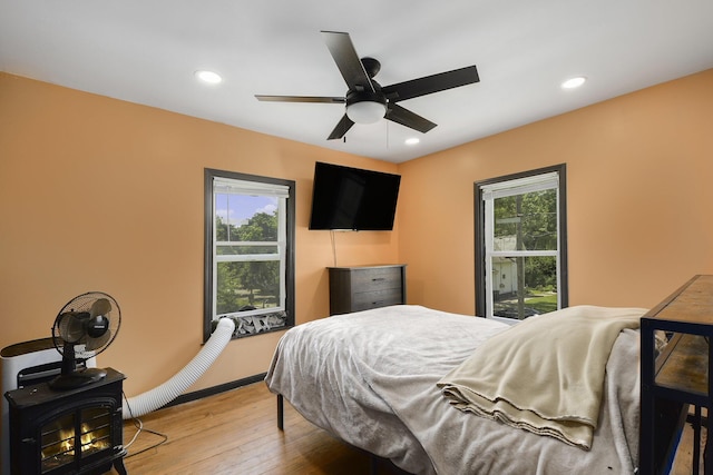 1211 S Jackson St, Jackson, MI 49203 - bedroom with wood-type flooring, recessed lighting, a wood stove, and ceiling fan