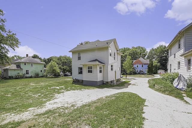 1211 S Jackson St, Jackson, MI 49203 - rear view of property with a lawn and driveway