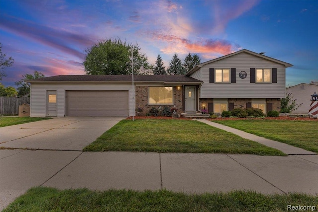 22031 Birch St, Woodhaven, MI 48183 - split level home featuring a garage, concrete driveway, and brick siding