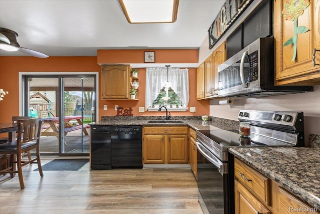 22031 Birch St, Woodhaven, MI 48183 - kitchen with appliances with stainless steel finishes, brown cabinets, ceiling fan, light wood-type flooring, and hanging light fixtures