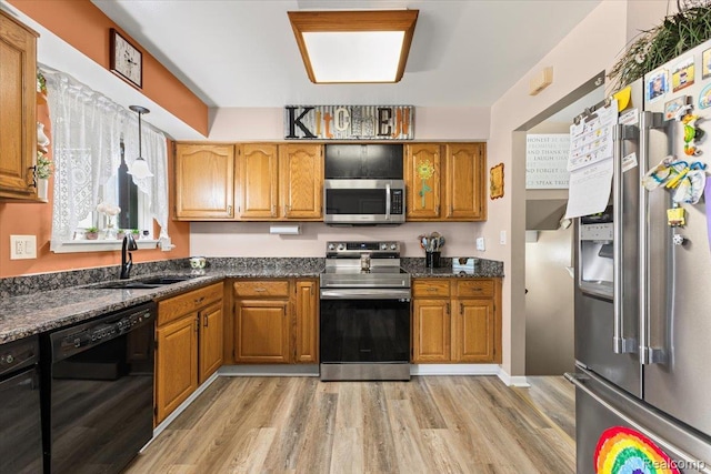 22031 Birch St, Woodhaven, MI 48183 - kitchen featuring stainless steel appliances, light wood-style floors, and brown cabinets