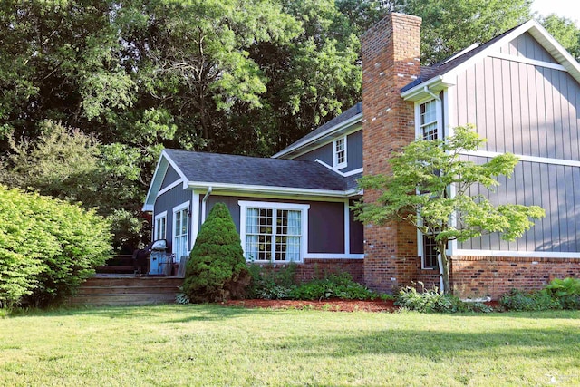 13578 Strasburg Rd, La Salle, MI 48145 - view of property exterior featuring a chimney, a lawn, and roof with shingles