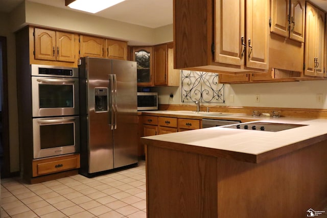 13578 Strasburg Rd, La Salle, MI 48145 - kitchen featuring appliances with stainless steel finishes, tile countertops, light tile patterned flooring, and a peninsula