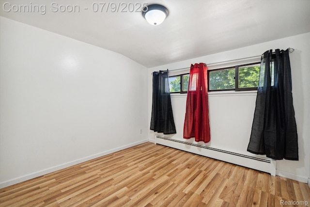 30590 Lorraine Ave, Warren, MI 48093 - spare room with baseboard heating, vaulted ceiling, and wood finished floors