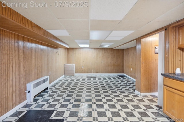 30590 Lorraine Ave, Warren, MI 48093 - finished below grade area with radiator, wooden walls, a paneled ceiling, and tile patterned floors