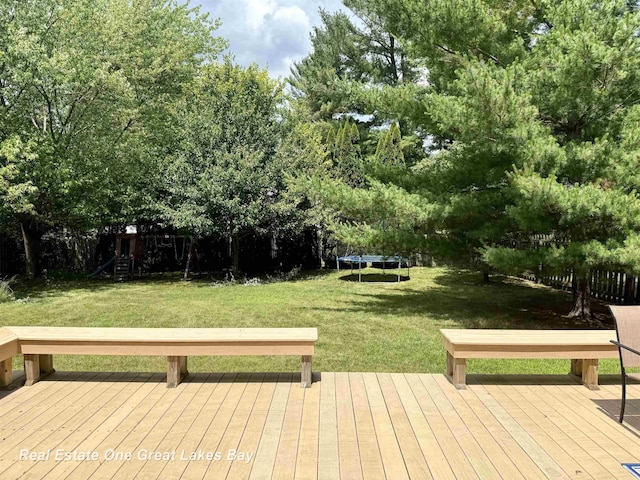 11540 Saddlebrook Cir, Freeland, MI 48623 - wooden deck with a trampoline, a yard, and view of wooded area