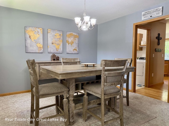 11540 Saddlebrook Cir, Freeland, MI 48623 - dining area with washer / clothes dryer, a chandelier, and light carpet