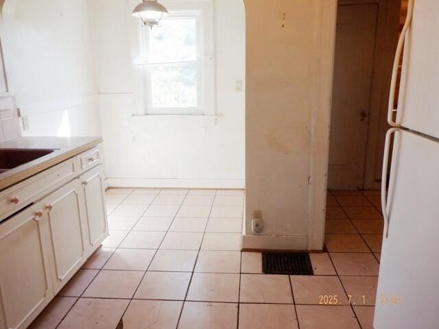 2535 Gull Rd, Kalamazoo, MI 49048 - kitchen with freestanding refrigerator, light tile patterned floors, white cabinetry, and light countertops