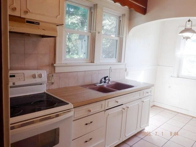 2535 Gull Rd, Kalamazoo, MI 49048 - kitchen with white range with electric stovetop, under cabinet range hood, plenty of natural light, and light countertops
