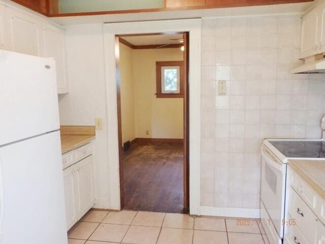 2535 Gull Rd, Kalamazoo, MI 49048 - kitchen with white appliances, light countertops, light tile patterned floors, and white cabinets