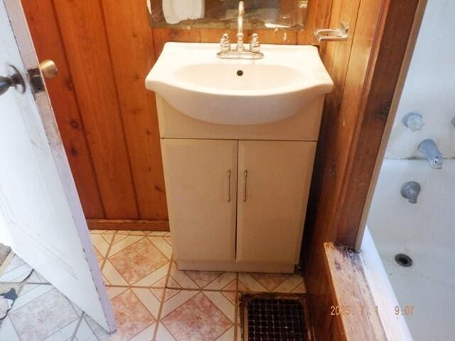 2535 Gull Rd, Kalamazoo, MI 49048 - bathroom featuring vanity, a bathtub, wooden walls, and a shower