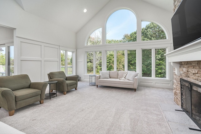 3603 Elk Ct, Zeeland, MI 49464 - living area with high vaulted ceiling, a stone fireplace, light carpet, and a decorative wall