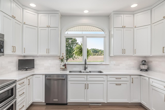 3603 Elk Ct, Zeeland, MI 49464 - kitchen featuring appliances with stainless steel finishes, light countertops, backsplash, white cabinetry, and recessed lighting