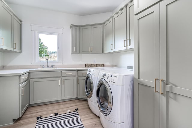 3603 Elk Ct, Zeeland, MI 49464 - laundry area with cabinet space, washer and clothes dryer, and light wood-type flooring