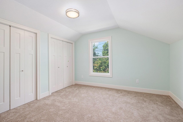854 First St NW, Grand Rapids, MI 49504 - unfurnished bedroom with carpet, two closets, and lofted ceiling