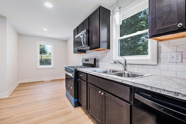 854 First St NW, Grand Rapids, MI 49504 - kitchen featuring appliances with stainless steel finishes, light countertops, decorative backsplash, light wood-style floors, and recessed lighting