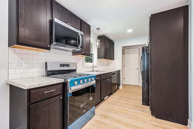 854 First St NW, Grand Rapids, MI 49504 - kitchen with stainless steel appliances, light wood-style flooring, dark brown cabinets, light countertops, and recessed lighting