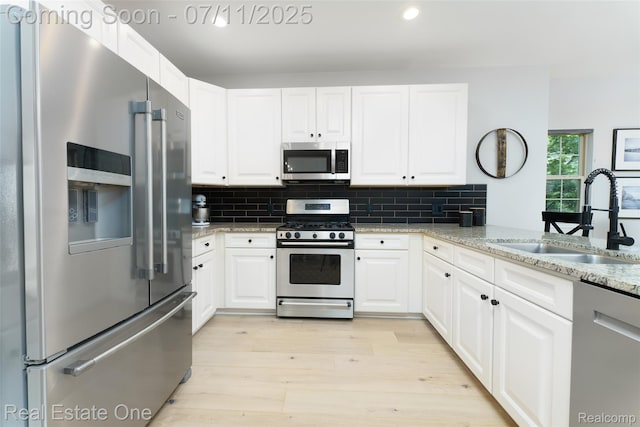 105 S 2nd St, Brighton, MI 48116 - kitchen featuring stainless steel appliances, light wood finished floors, backsplash, white cabinets, and recessed lighting