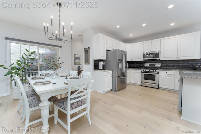 105 S 2nd St, Brighton, MI 48116 - kitchen with appliances with stainless steel finishes, backsplash, light wood-type flooring, a chandelier, and recessed lighting