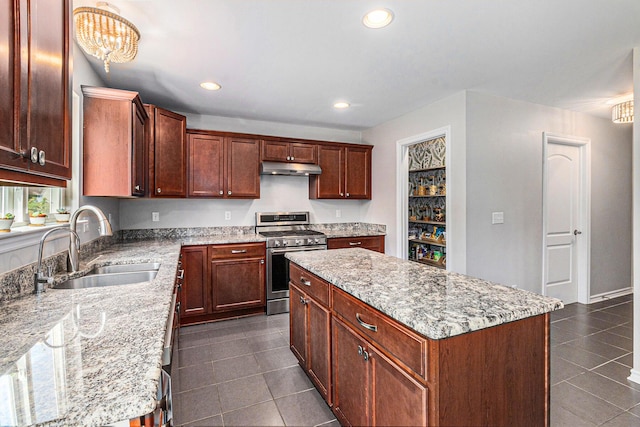 5775 Libby Ct, Dexter, MI 48130 - kitchen with gas range, under cabinet range hood, dark tile patterned flooring, light stone countertops, and recessed lighting