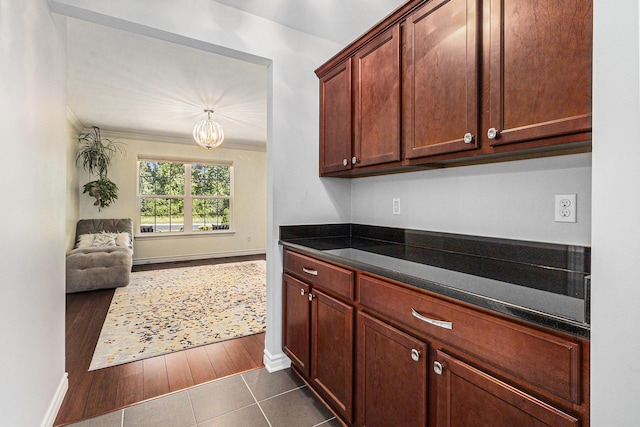 5775 Libby Ct, Dexter, MI 48130 - kitchen featuring a chandelier, dark tile patterned flooring, ornamental molding, and open floor plan
