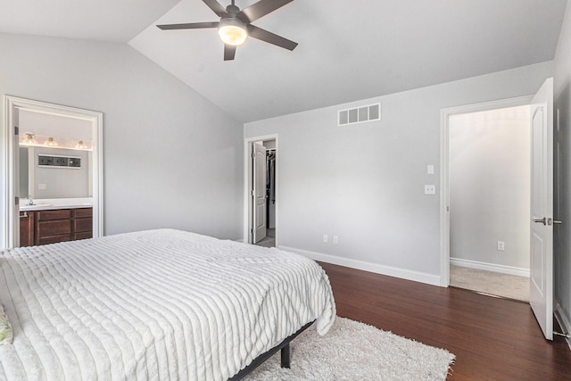 5775 Libby Ct, Dexter, MI 48130 - bedroom featuring dark wood-style flooring, vaulted ceiling, ensuite bathroom, a ceiling fan, and a walk in closet