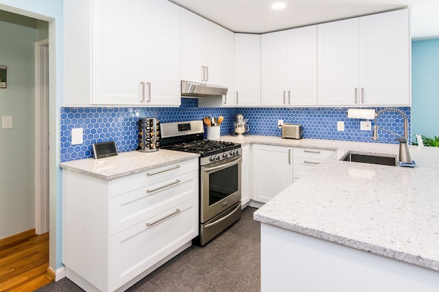 39079 Ross St, Livonia, MI 48154 - kitchen featuring stainless steel gas range, under cabinet range hood, light stone countertops, tasteful backsplash, and white cabinetry