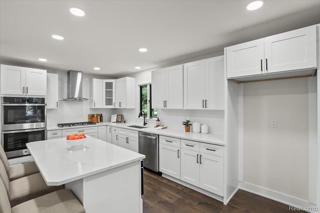 47043 Curtis Rd, Northville, MI 48168 - kitchen featuring wall chimney exhaust hood, appliances with stainless steel finishes, a center island, recessed lighting, and a kitchen bar