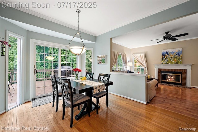 3066 Waldon Park Dr, Orion, MI 48359 - dining room featuring hardwood / wood-style flooring, ornamental molding, a brick fireplace, and a ceiling fan