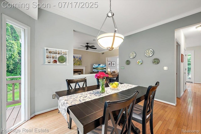 3066 Waldon Park Dr, Orion, MI 48359 - dining space featuring light wood-style flooring, a ceiling fan, crown molding, and a fireplace
