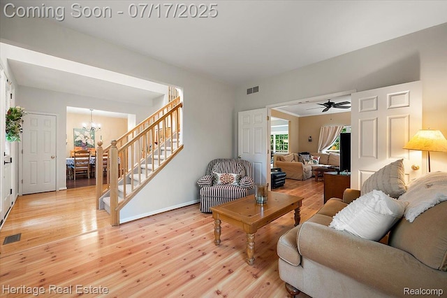 3066 Waldon Park Dr, Orion, MI 48359 - living room featuring stairs, light wood finished floors, a chandelier, and ceiling fan