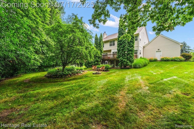 3066 Waldon Park Dr, Orion, MI 48359 - view of grassy yard with an outdoor fire pit and a wooden deck