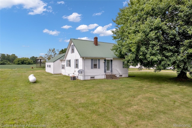 4677 Imlay City Rd, Attica, MI 48412 - rear view of house featuring entry steps, a yard, a chimney, and a metal roof