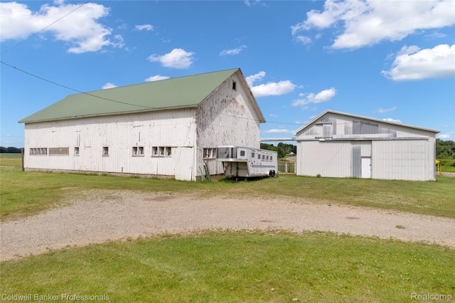 4677 Imlay City Rd, Attica, MI 48412 - view of side of property with a lawn, an outdoor structure, a garage, a metal roof, and a barn