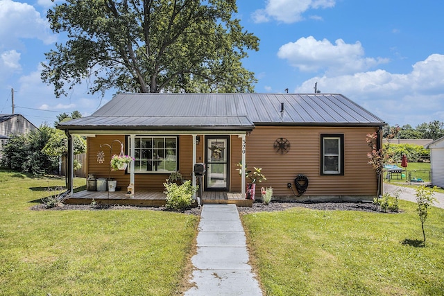 320 E Dr, Marshall, MI 49068 - bungalow with covered porch, a front yard, and a metal roof