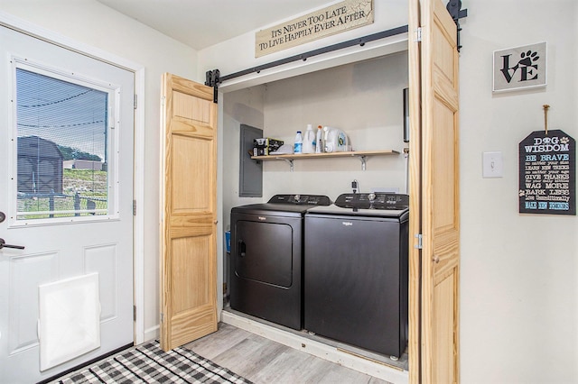 320 E Dr, Marshall, MI 49068 - washroom with a barn door, separate washer and dryer, and light wood-style flooring