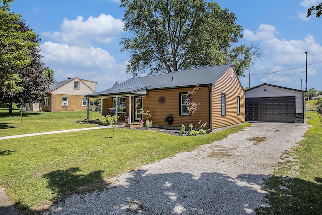 320 E Dr, Marshall, MI 49068 - view of front of property featuring covered porch, an outdoor structure, a front yard, a detached garage, and a metal roof