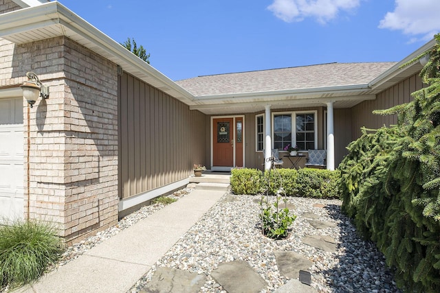 6177 Heathcross Dr, Hudsonville, MI 49426 - property entrance featuring a porch, a shingled roof, and an attached garage