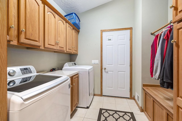 6177 Heathcross Dr, Hudsonville, MI 49426 - laundry room with separate washer and dryer, cabinet space, light tile patterned floors, and a textured ceiling