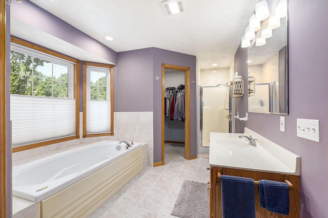 6177 Heathcross Dr, Hudsonville, MI 49426 - bathroom with a bath, vanity, a shower stall, a spacious closet, and tile patterned floors