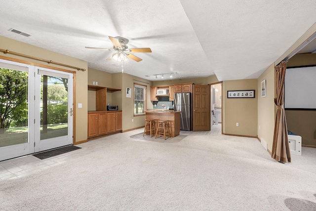 6177 Heathcross Dr, Hudsonville, MI 49426 - unfurnished living room with a textured ceiling, a ceiling fan, light colored carpet, and rail lighting