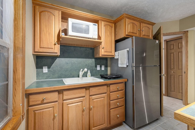 6177 Heathcross Dr, Hudsonville, MI 49426 - kitchen with freestanding refrigerator, white microwave, backsplash, light tile patterned floors, and brown cabinets