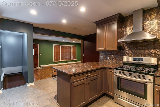 1432 N Custer Ave, Clawson, MI 48017 - kitchen with wall chimney range hood, stainless steel gas stove, a peninsula, tasteful backsplash, and dark stone counters