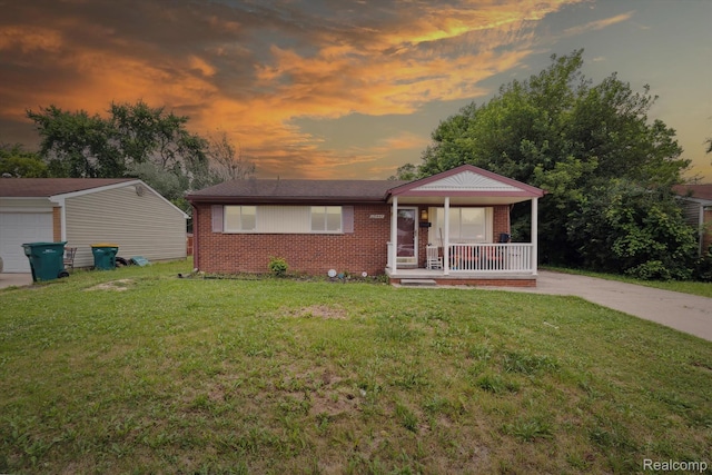 15447 Taft St, Westland, MI 48174 - view of front of home with a porch, brick siding, a front yard, and a garage